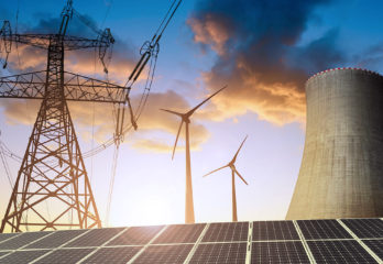 display of clean energy systems: power grid, wind turbines, nuclear reactor, and solar panels.